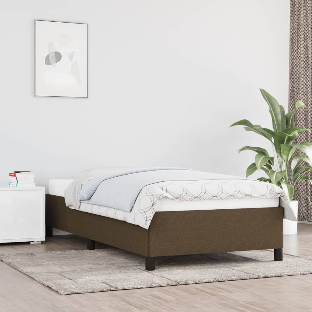 Estructura de cama marrón oscuro sin colchón, 90x190 cm, en dormitorio moderno con planta y decoración minimalista.