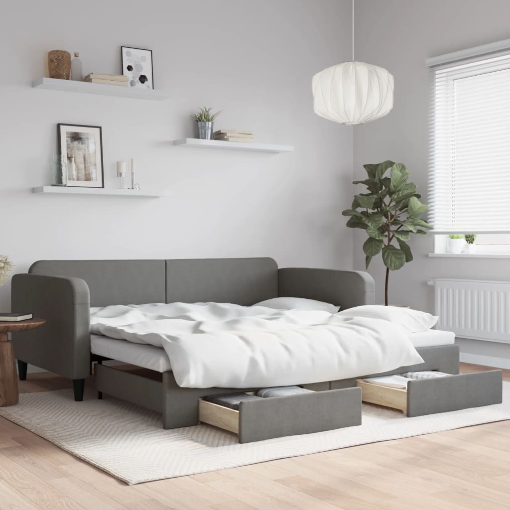 Sofá cama nido gris oscuro con cajones, estilo moderno en salón, cama doble desplegada y decoraciones minimalistas.