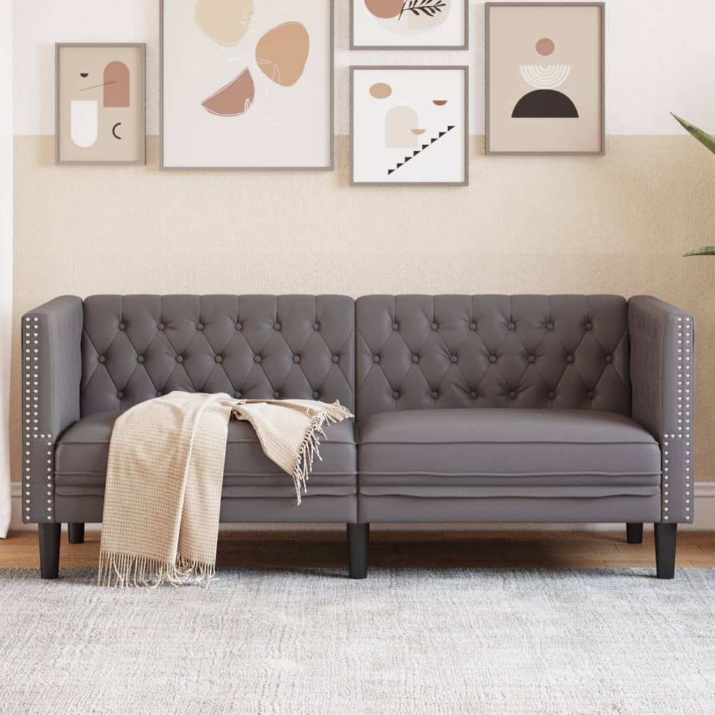 Sofá Chesterfield de 2 plazas en cuero artificial gris, ideal para relajarse y decorar espacios elegantes.