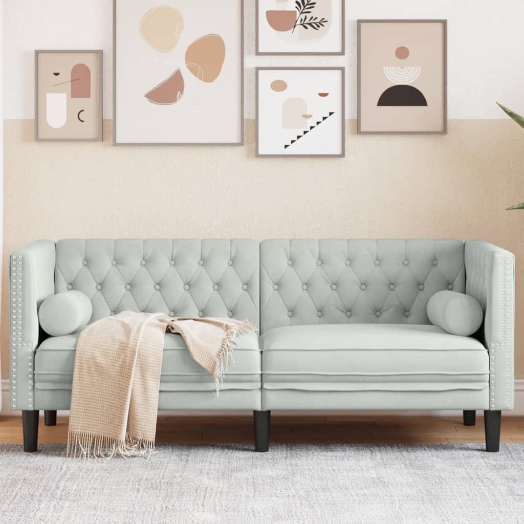 Sofá Chesterfield de 2 plazas en terciopelo gris claro con cojines, decorado con arte moderno en la pared.