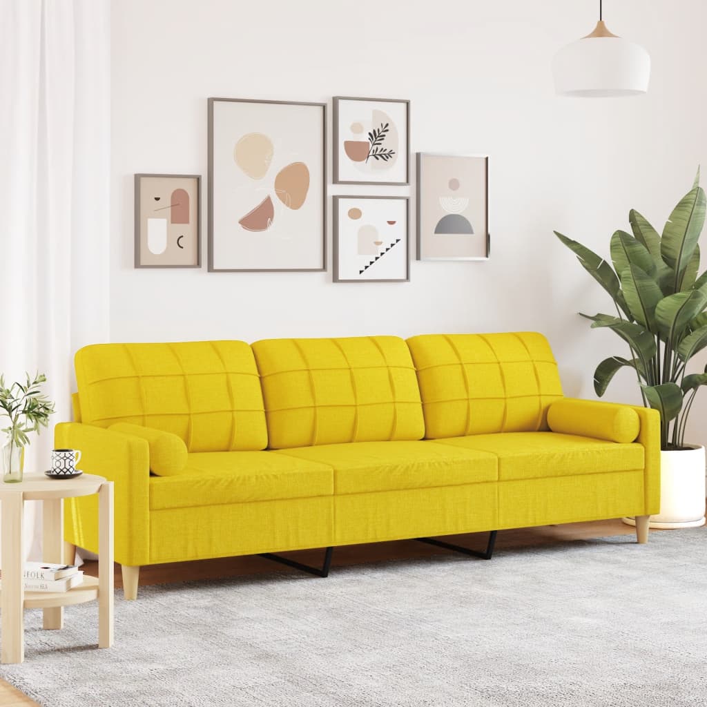 Sofá de 3 plazas amarillo claro con cojines, ideal para lectura y relajación, en un ambiente moderno y acogedor.