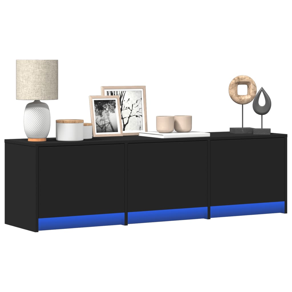 Mueble de TV negro con luces LED azules, decorado con lámpara y cuadros, diseño moderno y práctico.