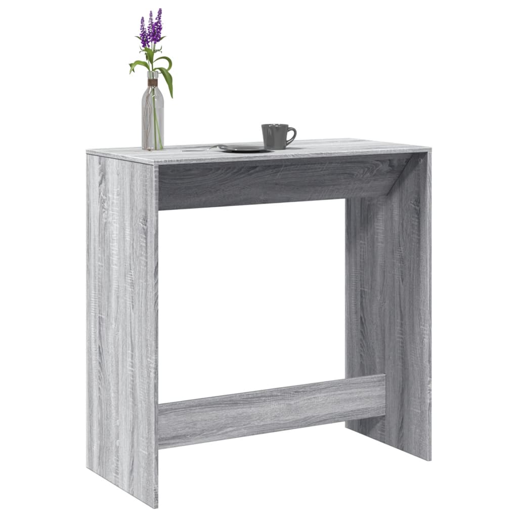 Mesa alta de bar de madera gris con decoración de flores y taza, ideal para cocina o sala de estar.