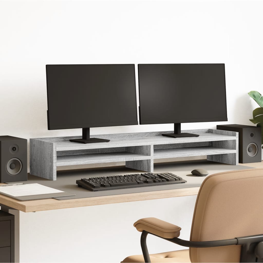 Soporte de pantalla de madera gris con dos monitores, teclado y altavoces en un escritorio elegante.