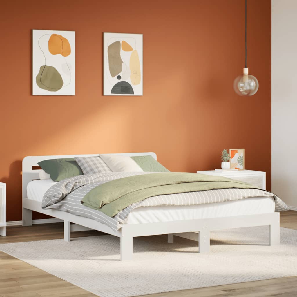 Estructura de cama de madera blanca de pino con almohadas y mantas en dormitorio moderno, paredes de color terracota.