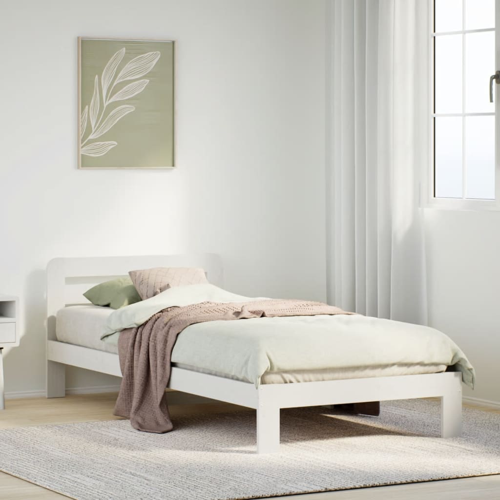 Estructura de cama blanca de madera maciza en dormitorio acogedor, decorada con mantas y cojines.