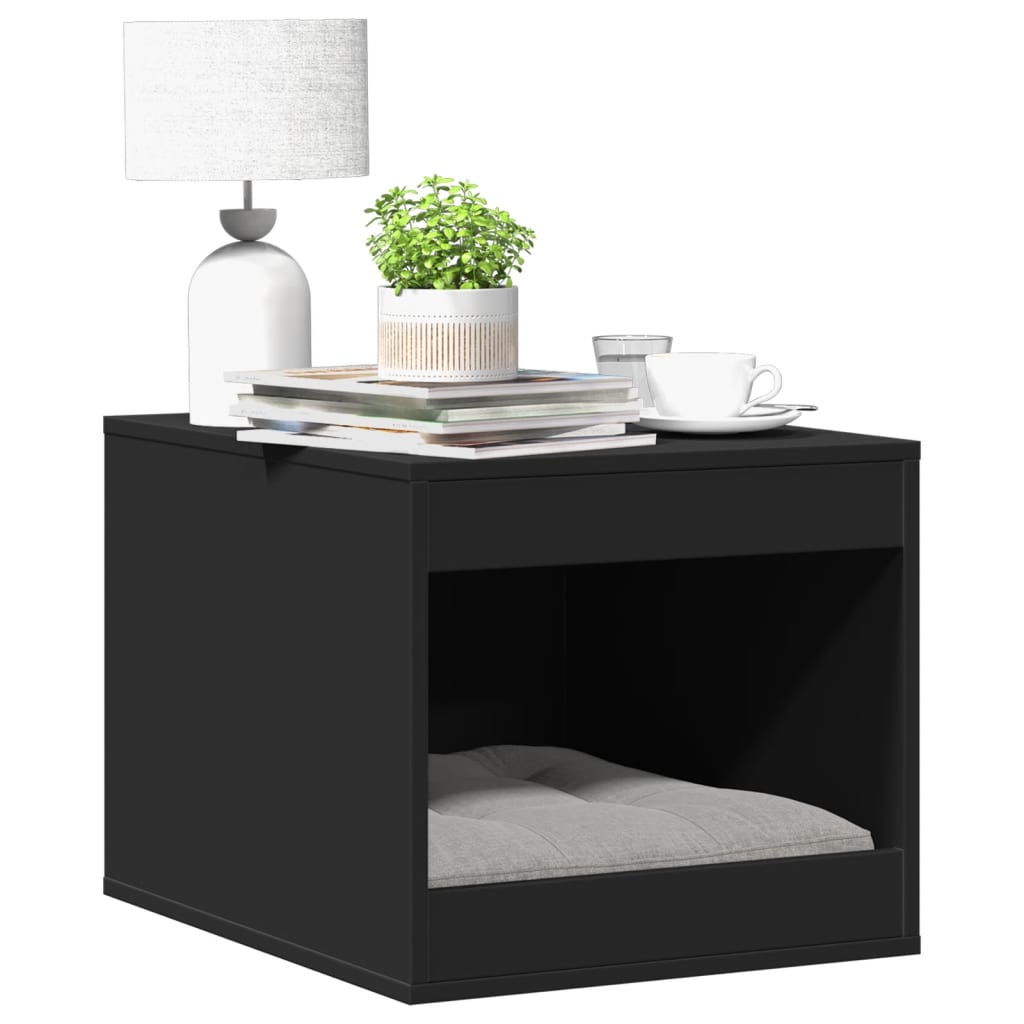 Mueble arenero para gatos en color negro con espacio oculto, decorado con lámpara, planta y libros en la parte superior.