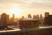 Remate de chimenea Coca de hormigón con textura de ladrillo, coronación de la salida de humos en un edificio urbano moderno al atardecer - Vetonek