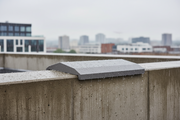 Cubremuros Cinca de hormigón gris, remate del muro de un ático urbano bajo la lluvia - Vetonek