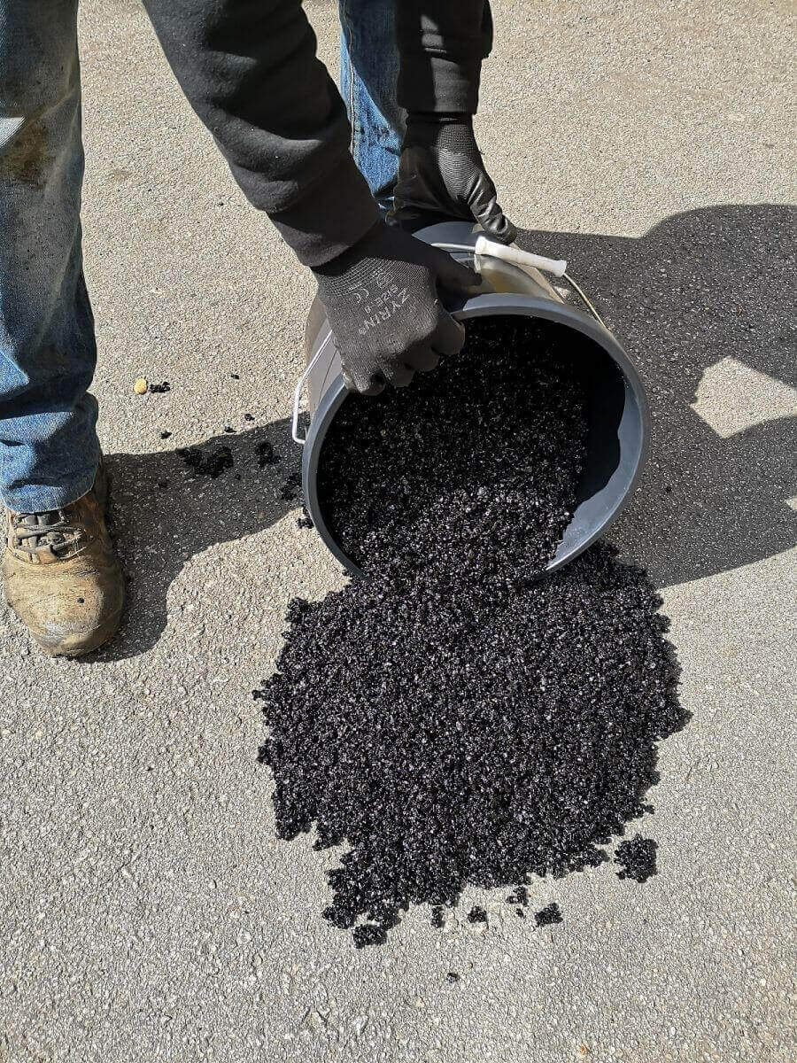 Asfalto en frío Vetonek: vertido del aglomerado desde el envase de 25 kg sobre el pavimento