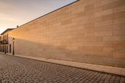 Muro de piedra en un edificio historico de casco antiguo revestido con Aplacado Poblet al atardecer