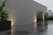 Muro exterior revestido con Aplacado Poblet en una terraza urbana bajo lluvia suave