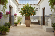Patio interior andaluz con Losa Frías Travertino de hormigón en caliza y naranjo - Vetonek