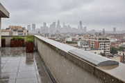 Cubremuros Cinca de hormigón, en el peto de una azotea urbana bajo la lluvia - Vetonek