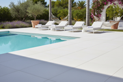 Zona chill-out junto a piscina pavimentada con Losa Medinaceli de hormigón en blanco - Vetonek