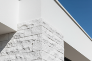 Esquina de fachada de vivienda mediterranea moderna rematada con Piedras de Angulo Poblet color blanco