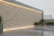 Muro de cerramiento urbano revestido con Plaqueta Labrada de hormigón bajo lluvia suave - Vetonek