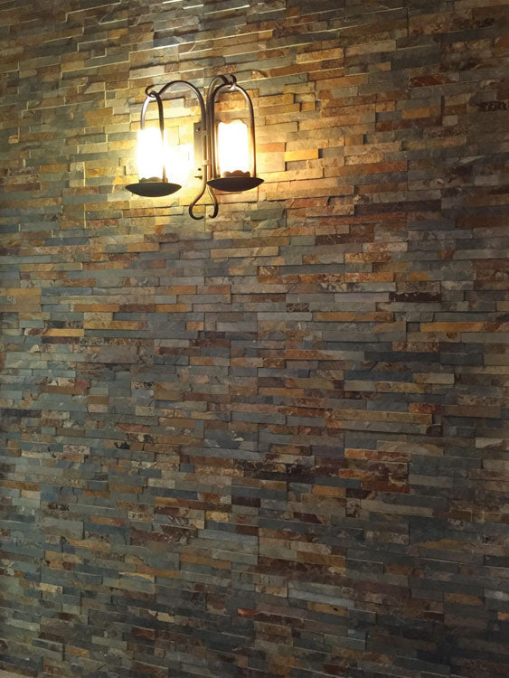 Pared interior con paneles de piedra natural Miranda óxido iluminada con aplique