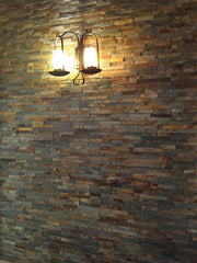 Pared interior con paneles de piedra natural Miranda óxido iluminada con aplique