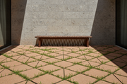 Patio interior minimalista con Adoquín Chinchón Triangular de hormigón en marrón y muro de piedra - Vetonek
