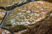 Primer plano de gotas de agua sobre piedra artificial tratada con el hidrófugo de efecto mojado Levante - Vetonek